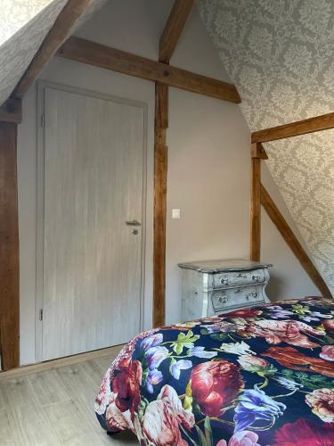 - une chambre avec un lit doté d'un couvre-lit floral et d'une porte dans l'établissement Au cœur de l'Alsace, à Turckheim