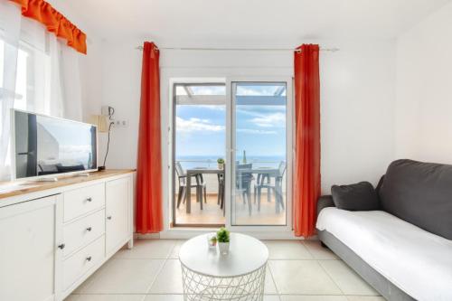 a living room with a couch and a television at Villa Buraux III in Roses