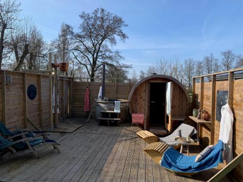 a wooden deck with chairs and a building at Kampari in Delfstrahuizen