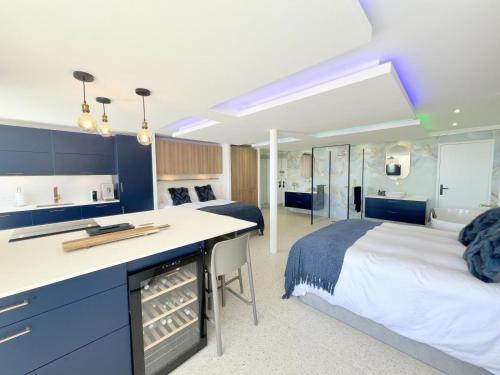 Cet appartement comprend une chambre avec deux lits et une cuisine avec un comptoir. dans l'établissement Studio 210, Héliopolis AB, Village naturiste, au Cap d'Agde