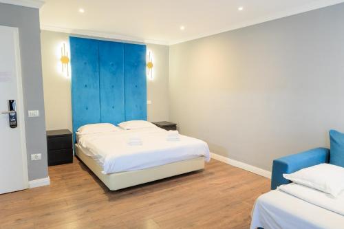 a bedroom with two beds and a blue door at The Embassy Nord in Bucharest