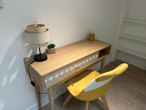 a desk with a lamp and a yellow chair at Le Cocon Niortais in Niort