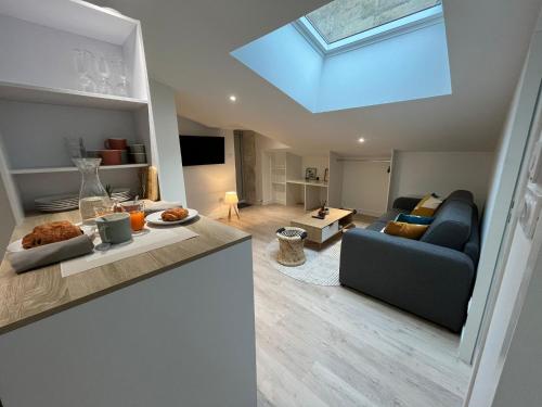 a living room with a couch and a skylight at Le Cocon Niortais in Niort