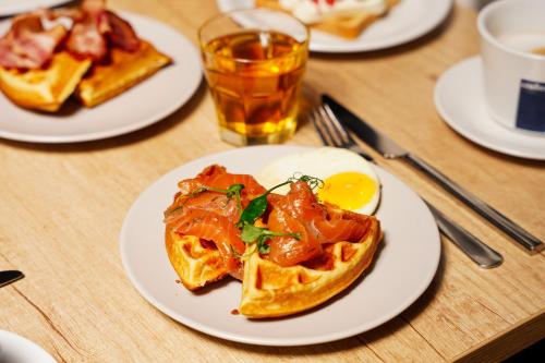 a table with plates of breakfast food on it at Loop Hotel Vilnius in Vilnius