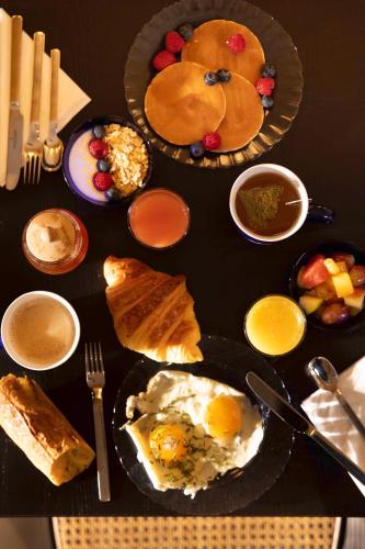 a table topped with plates of food with eggs and bread at Hotel Locomo - Gare de Lyon Bastille in Paris
