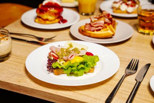 a wooden table with plates of food on it at Loop Hotel Vilnius in Vilnius