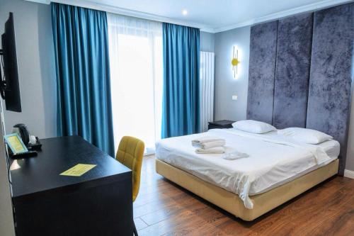 a bedroom with a bed and a desk and a table and a desk at The Embassy Nord in Bucharest