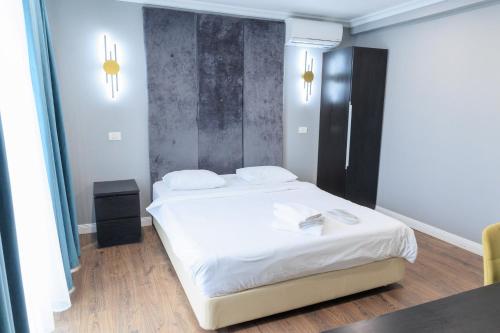 a bedroom with a large white bed with white sheets at The Embassy Nord in Bucharest
