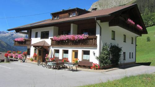 a building with flowers on the balconies and a table at Gästehaus Klug in Bschlabs