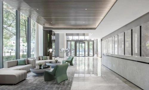 a living room with a couch and tables and windows at Crystal Orange Hotel Shanghai Hongqiao Hub Railway Station in Shanghai