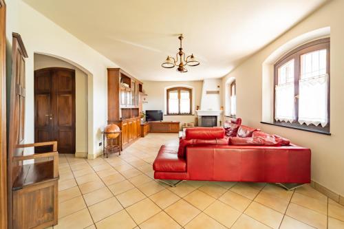 a living room with a red couch and a kitchen at Tenuta Oltrevento in Dogliani