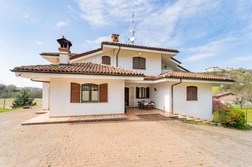 a large white house with a brick driveway at Tenuta Oltrevento in Dogliani