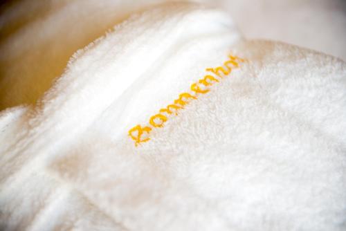 a white towel with the word satisfaction written on it at Hotel Sonnenhof in Merano
