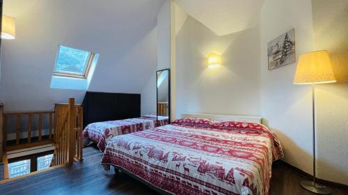 a hotel room with two beds and a lamp at Residence Villa Frejus in Bardonecchia