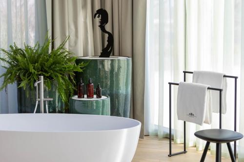 a bathroom with a bath tub and a plant at Ca' Apollonio Heritage in Romano D'Ezzelino
