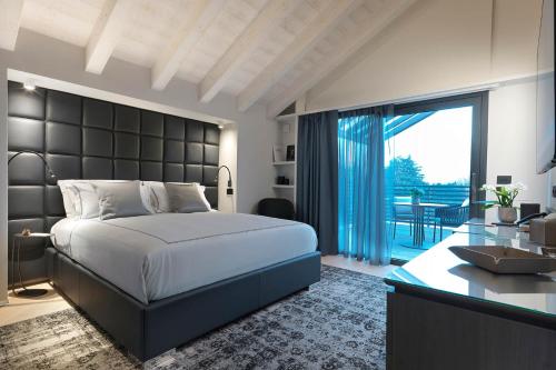a bedroom with a large bed and a desk and a balcony at Ca' Apollonio Heritage in Romano D'Ezzelino