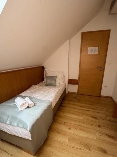 a bedroom with a bed with two towels on it at Belvárdi Fogadó in Belvárdgyula