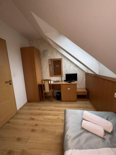 a attic room with a bed and a desk at Belvárdi Fogadó in Belvárdgyula