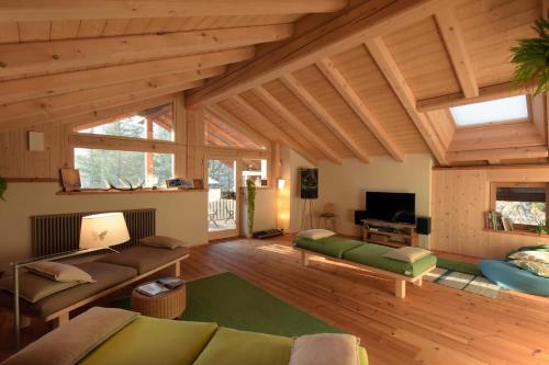 a large living room with wooden ceilings and wooden floors at B&B Mas de Lagorae in Tesero