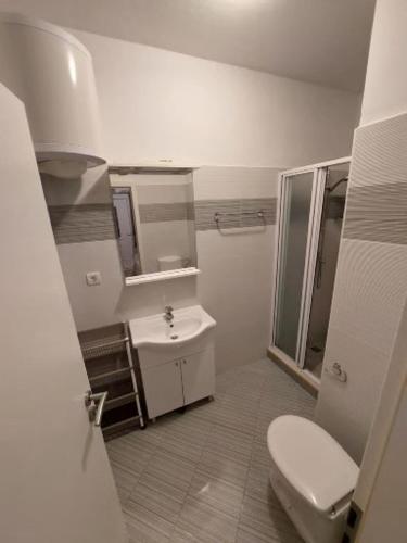 a bathroom with a toilet and a sink at Apartments and Rooms King in Mokošica