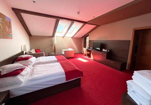 a bedroom with a large bed with a red carpet at Wellness Hotel Chopok in Demanovska Dolina