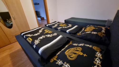 two beds with black and gold comforters at Ferienwohnungen und Zimmer in Nordhausen in Nordhausen