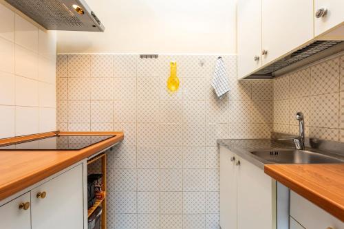 Una cocina con gabinetes blancos y un fregadero. en Casa Musa Giardini Naxos, en Giardini Naxos
