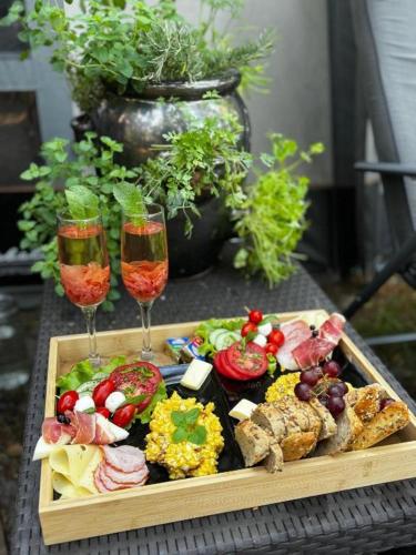 a tray of food and two wine glasses on a table at Caravana Juliana Hobby 545 z widokiem na Jezioro in Swaderki