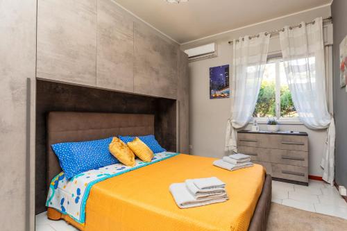 1 dormitorio con cama con almohadas azules y lavamanos en Casa Musa Giardini Naxos, en Giardini Naxos