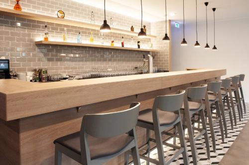 a bar with a row of chairs lined up behind it at Holiday Inn Express Neunkirchen by IHG in Neunkirchen