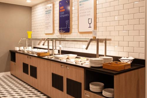 a kitchen with a counter with plates and dishes at Holiday Inn Express Neunkirchen by IHG in Neunkirchen