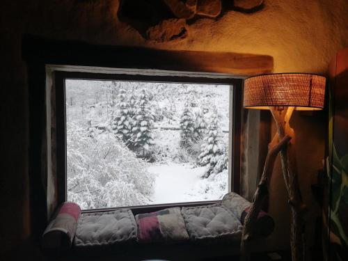 ein Fenster in einem Zimmer mit Sofa und Lampe in der Unterkunft Le Cocon du Vivarais in Rochepaule