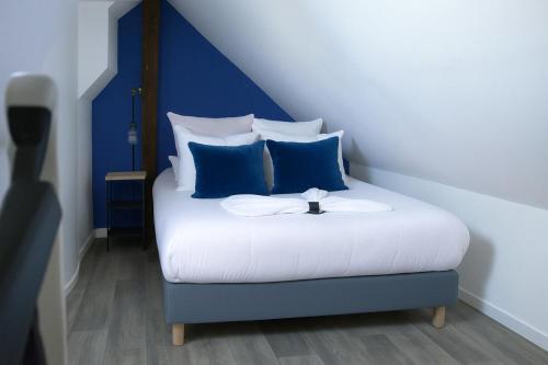 a bedroom with a bed with blue and white pillows at Le Bleuet in Chartres