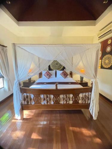 a bedroom with a bed with a canopy at Baan Orapin in Chiang Mai