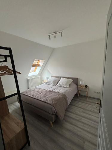 une chambre avec un lit dans une pièce avec une fenêtre dans l'établissement L'écrin des remparts, à Sedan