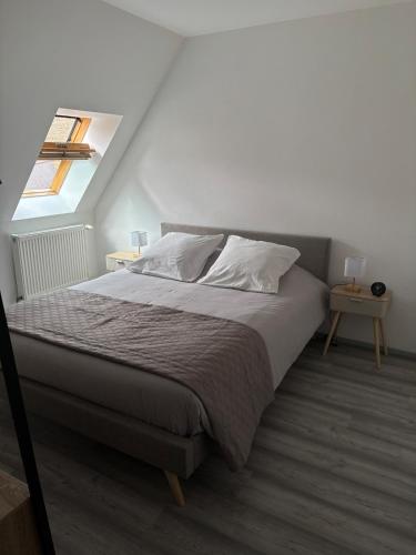 une chambre avec un grand lit avec une fenêtre dans l'établissement L'écrin des remparts, à Sedan