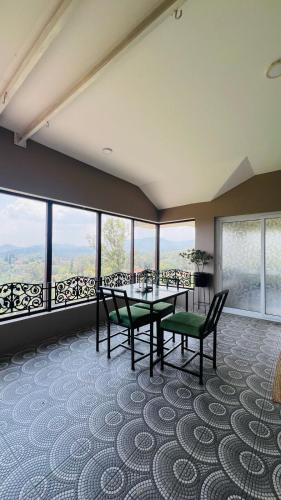 a dining room with a table and chairs and windows at Sunset Villa in Coonoor