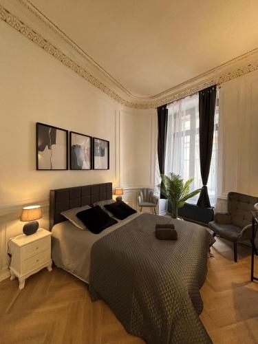une chambre avec un lit, un canapé et une chaise dans l'établissement Le petit boudoir de Beziers, à Béziers