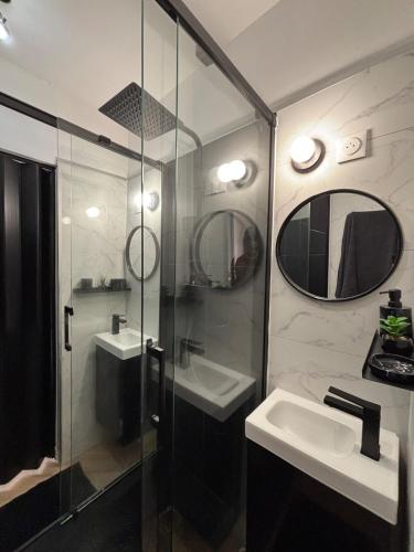 une salle de bain avec une douche, un lavabo et un miroir dans l'établissement Le petit boudoir de Beziers, à Béziers