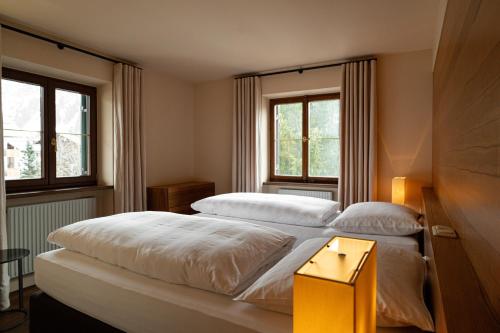 two beds in a room with two windows at Hinterwies – Ski In / Lodge / Dine in Lech am Arlberg
