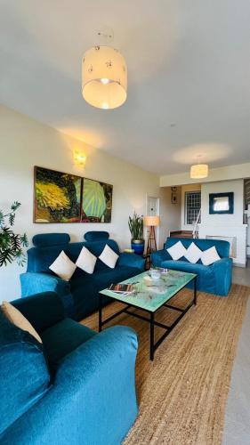 a living room with blue couches and a glass table at Sunset Villa in Coonoor