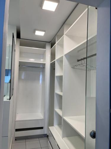 a walk in closet with white shelves and a glass door at Luxury 4BR New Cairo Villa with Pool & Stylish Living - FAMILY ONLY in Cairo