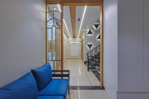 a living room with a blue couch and a staircase at HOTEL SERA, Vadodara in Vadodara
