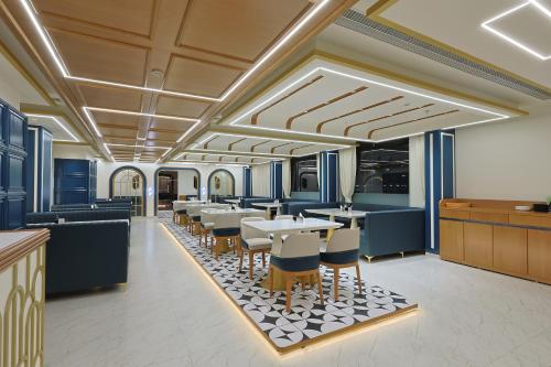 a rendering of a restaurant with tables and chairs at HOTEL SERA, Vadodara in Vadodara