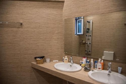 a bathroom with two sinks and a mirror at Garden Villa Patra in Flámbouras