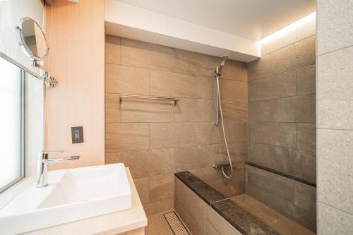a bathroom with a sink and a shower at Solvana Akasaka in Tokyo