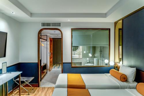 a bedroom with a bed and a desk at Graph Hotels Bangkok in Bangkok