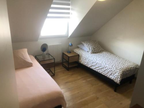 - une chambre mansardée avec 2 lits et une fenêtre dans l'établissement La Villa Ker Mi'mil, à Saint-Gildas-de-Rhuys