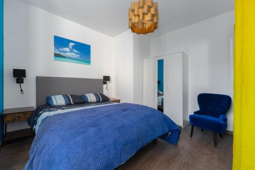 une chambre avec un lit bleu et une chaise bleue dans l'établissement Vieux-Port - Le Thiars, à Marseille