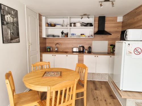 eine Küche mit einem Holztisch und einem weißen Kühlschrank in der Unterkunft Grand Studio Lumineux pour 4 personnes in Bois-dʼArcy